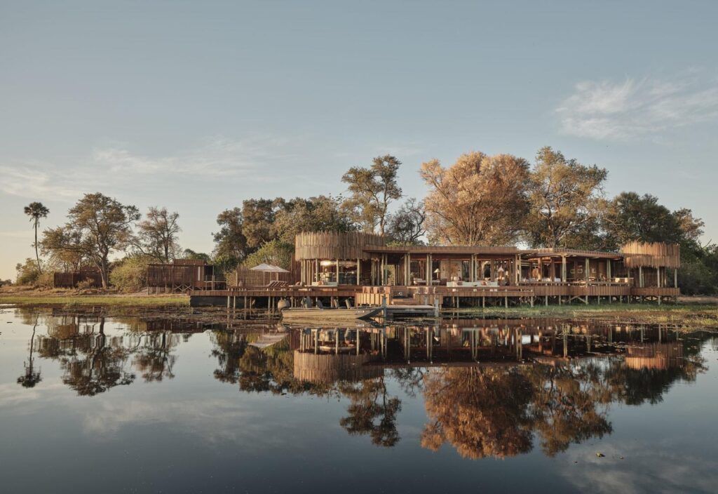Baines’ Lodge reflected in calm water in the Okavango Delta