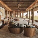 Main lodge lounge with sofas and open views at Baines’ Lodge, Okavango Delta, Botswana.