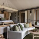 Luxury room interior with king-size bed, stylish living area, and natural wood accents in a tented suite at Chitabe Camp