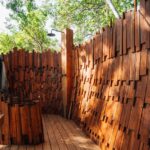Outdoor shower at Chitabe Camp, surrounded by lush vegetation in the Okavango Delta
