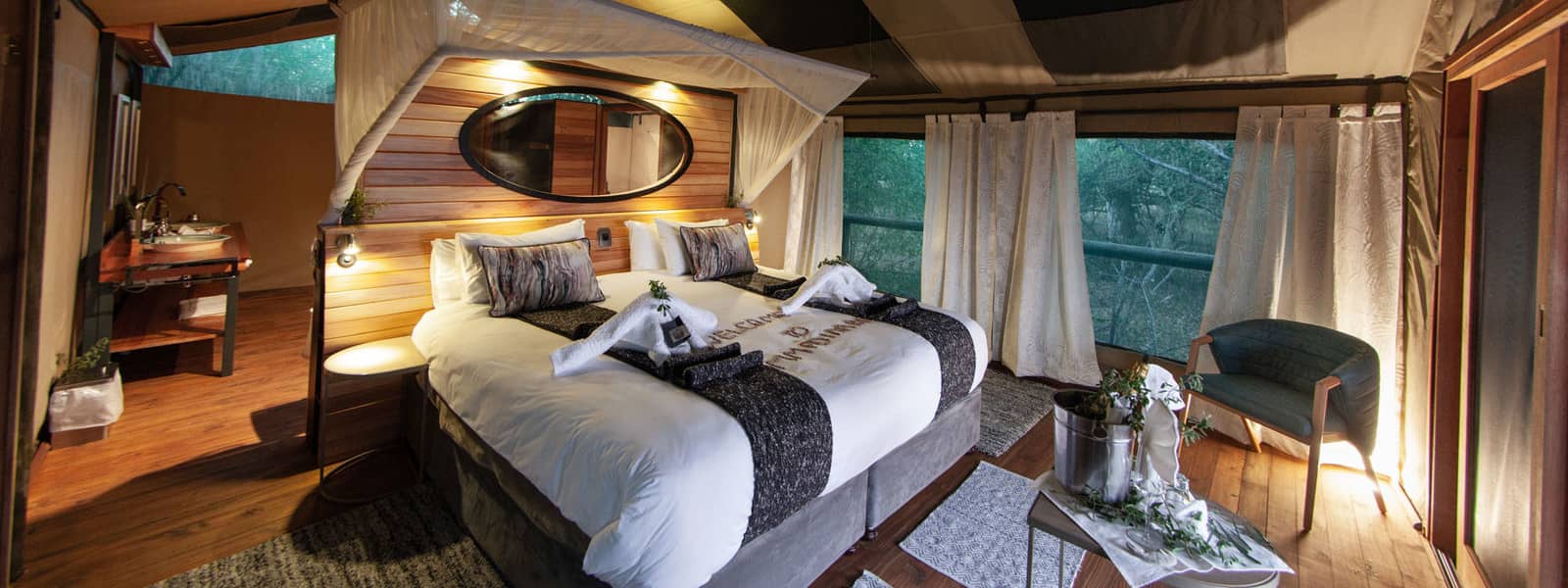 Elegant safari tent interior with a king-size bed and panoramic views at Mma Dinare Camp.