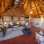 Open thatched lounge area with comfortable seating and warm lighting.