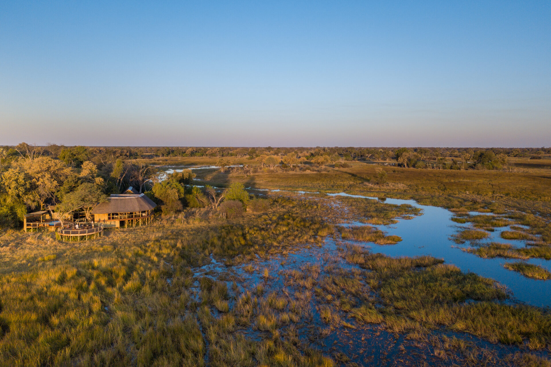 Drone shot of Mma Dinare Camp beside the Gomoti River floodplains in the Okavango Delta.