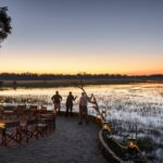 Sundown at Chief's camp accentuated by firepit and Okavango Delta backdrop
