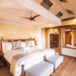 Luxury safari tent suite with canopy bed and open bathroom at Kwara Camp.