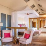 Luxury safari tent suite with canopy bed and seating area at Kwara Camp.