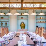 Elegant dining room with long wooden table set for guests at Kwara Camp.