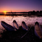 Mokoro canoe safari at sunset on the Okavango Delta near Kwara Camp.