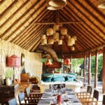 Dining room table set up under thatch at Mapula Lodge