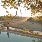 An African sunset peeks over the mountains in full view of Meno a Kwena's swimming pool