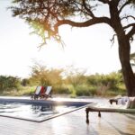 The inviting swimming pool deck at sunrise at Camp Kalahari