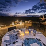 Dining table set outside against early evening sky at Sable Alley
