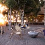 The large deck of Xugana Island Lodge is nestled between the trees and offers plenty of space for guests to spread out