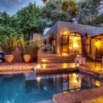 Private dinner tables set around the pool at Chobe Game Lodge