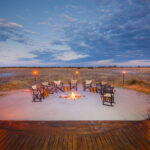 Campfire and chairs arranged in a circle overlooking the plains at Nxai Pan Camp.