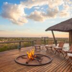 Campfire and seating area on wooden deck overlooking the plains at Tau Pan Camp.
