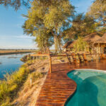 Pool and wooden deck overlooking river and grasslands at Lagoon Camp.