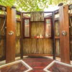 Wooden outdoor shower area with twin showerheads and rustic natural design.