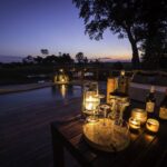Private dinner setup on pool deck at Mombo Camp