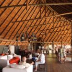 Thatched main lodge interior with sofas and bar area at Pom Pom Camp.