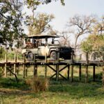 Safari vehicle crossing a wooden bridge in the Okavango Delta near Pom Pom Camp.