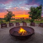 Fire pit focal against African sunset at Qorokwe Camp