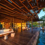 Main lounge and wooden deck area alongside pool at Qorokwe Camp