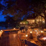 Evening scene of fire pit on wooden deck at Savuti Camp