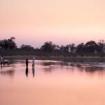Drinks at sundown with feet in the water at Selinda Explorers Camp