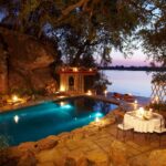 The swimming pool lit at night at the main lodge at Tongabezi