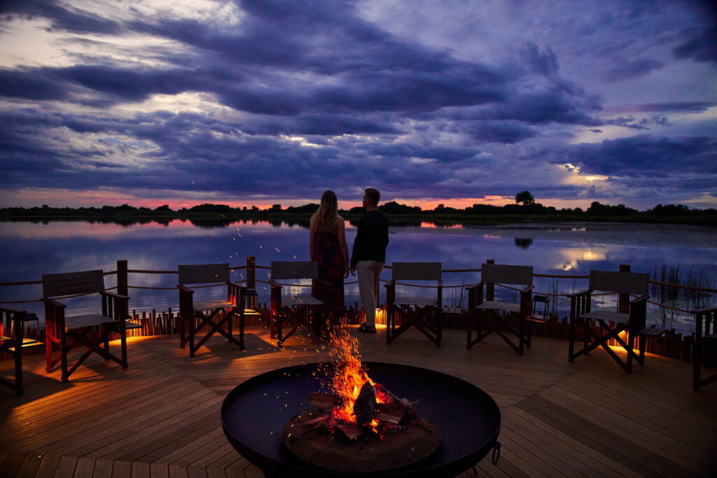 Guests enjoying sunset from the fire deck overlooking Xugana Lagoon.