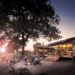 Linyanti Expeditions campfire and tent at sunset in Botswana.