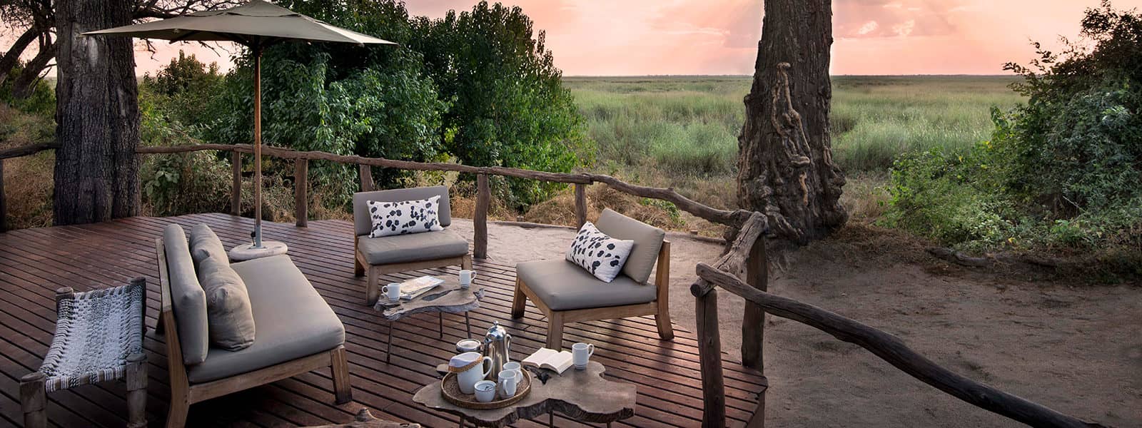Khwai Ebony Camp outdoor deck lounge with sofas and coffee setup overlooking the plains in Botswana.