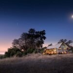Khwai Ebony Camp tent exterior illuminated at night under moonlight in Botswana.