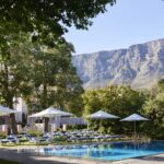 Table Mountain forms the perfect landscaped backdrop to Mount Nelson hotel 's sparkling swimming pool and deck