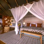Spacious suite tent with double four poster bed, mosquito net, lounge area and ensuite bathroom.