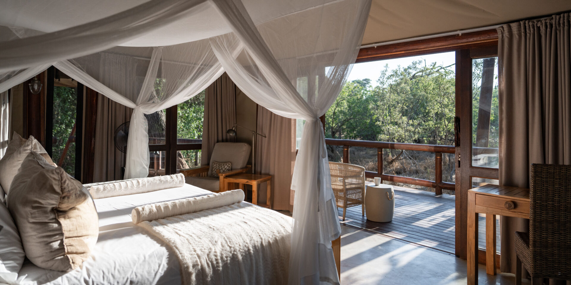 Spacious tented suite raised on wooden decking with views on to forest of Tuli Safari Lodge.