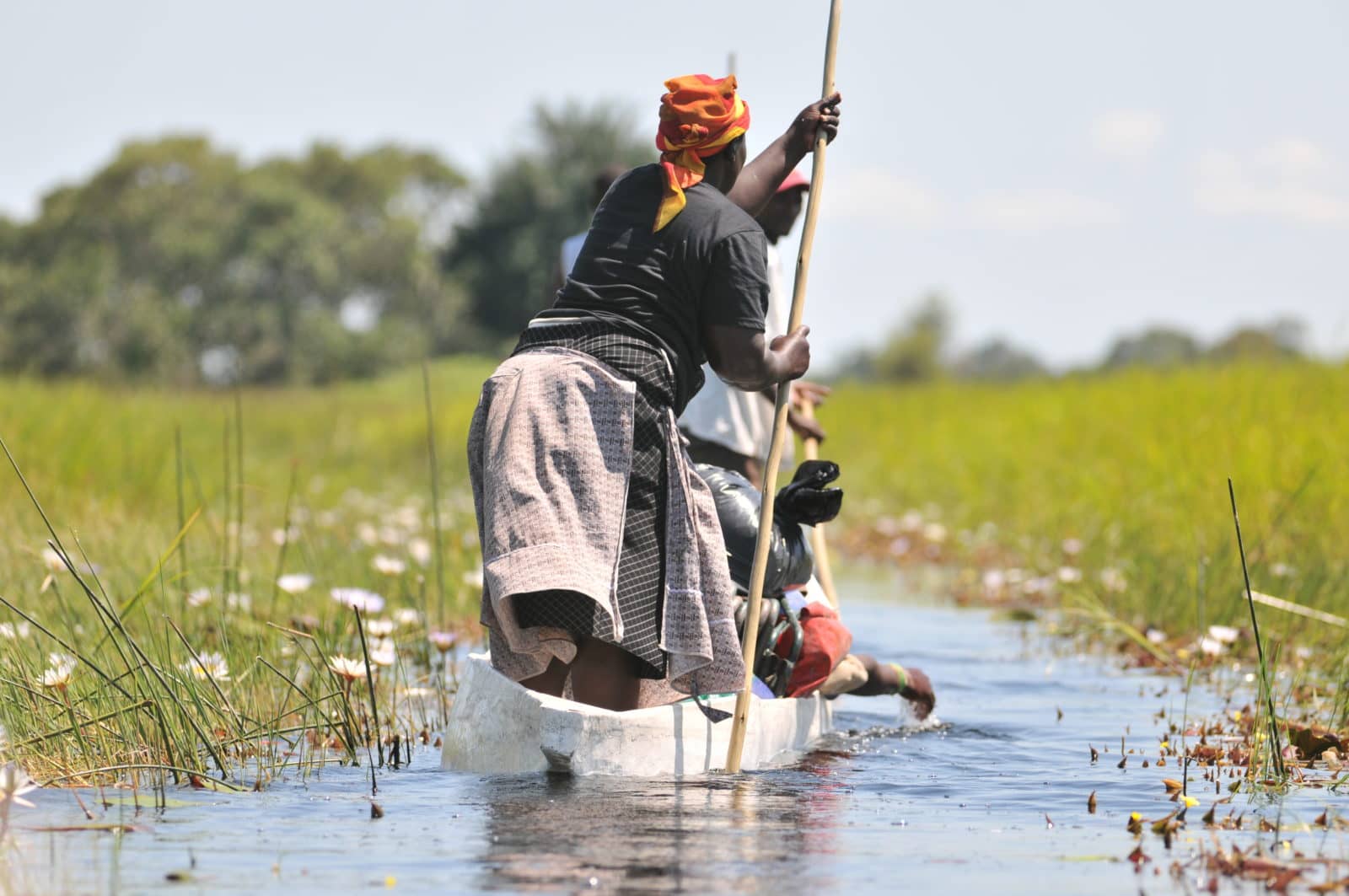 Ladies poling a mokoro from the village supported through sustainable tourism