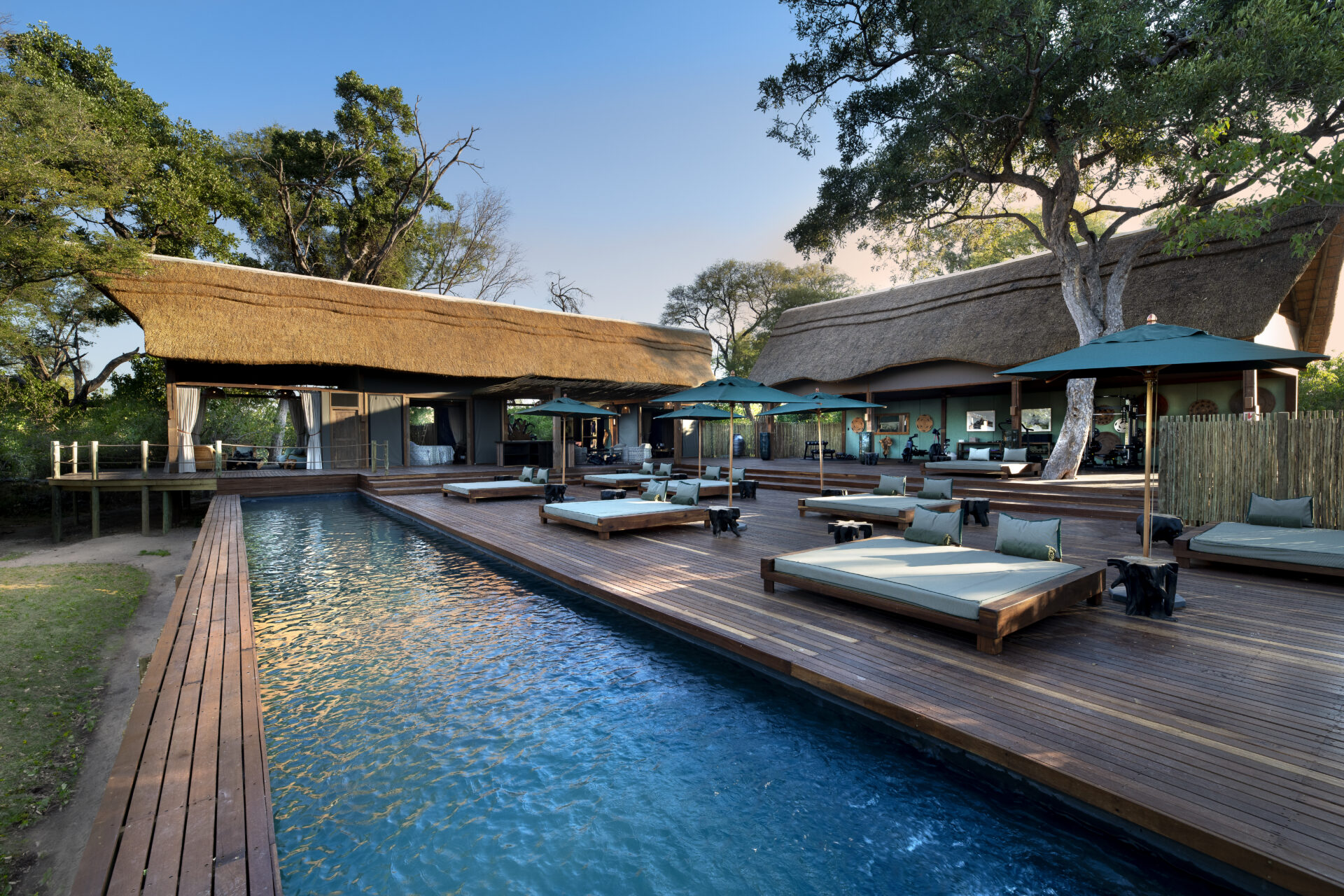 Atzaró Okavango Camp swimming pool and sun loungers on wooden deck in Botswana.
