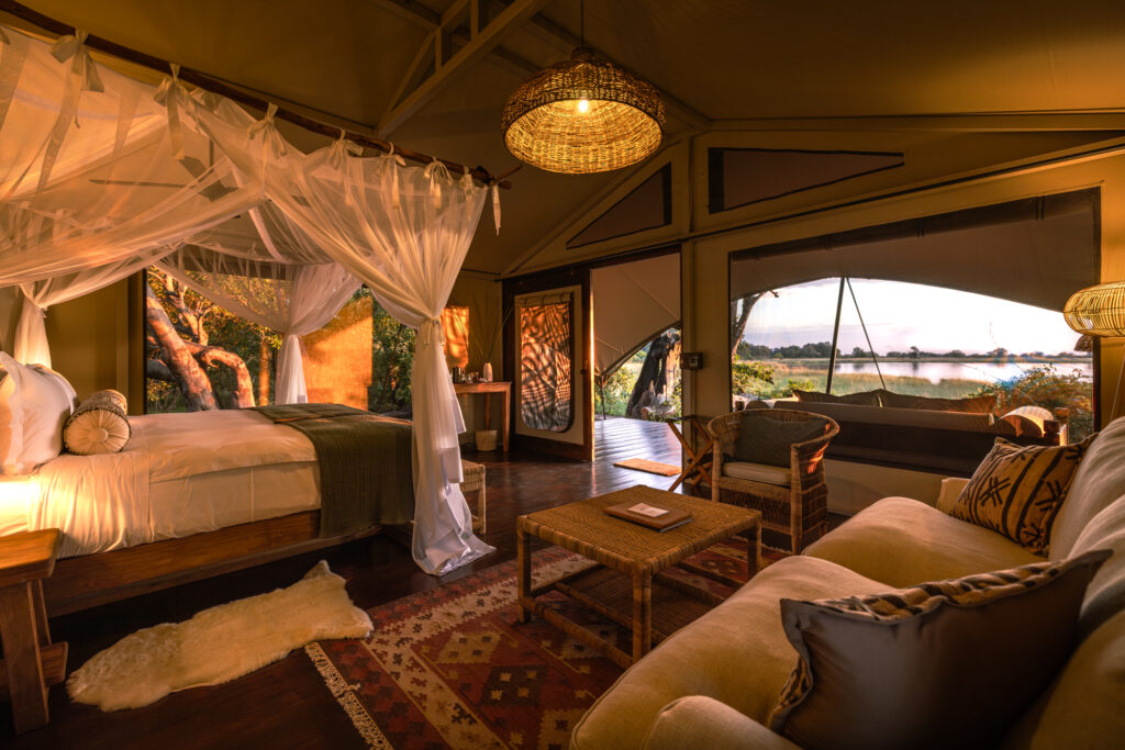 Elegant safari-style bedroom at Maxa in Botswana with a king bed, natural wood accents, and woven décor