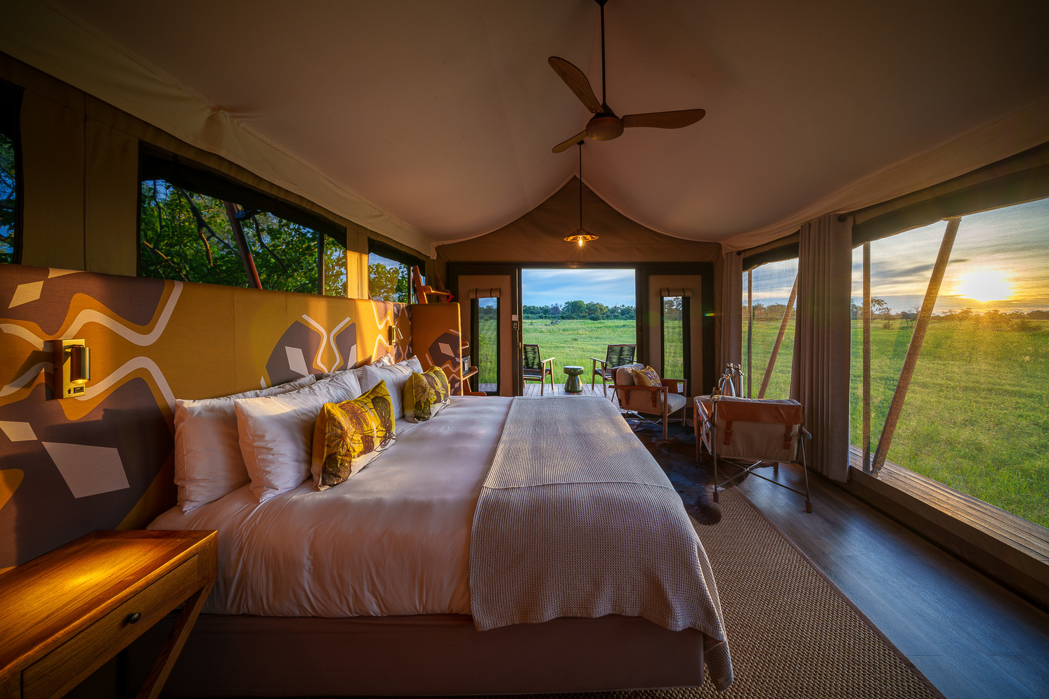 Luxury tented suite at Karangoma Camp overlooking the Okavango Delta floodplains, surrounded by shaded woodland.