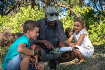 Children on safari at Vumbura learning with a safari guide