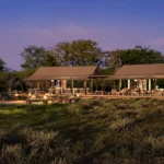 Nkasa Linyanti camp lit up at night overlooking the floodplains