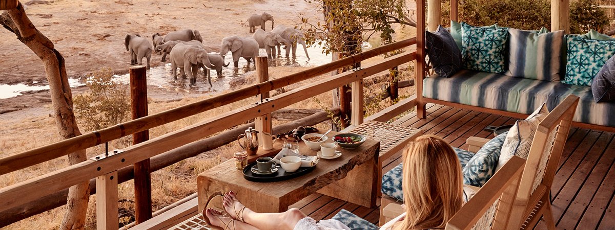 A guest at Savute elephant lodge watching elephants from her balcony