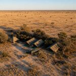 Aerial view of a small tented safari camp by Harkness Safaris set within the expansive Central Kalahari landscape.